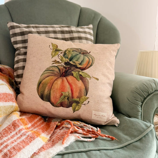vintage pumpkin decorative pillow cover with a botanical-style pumpkin illustration in warm autumn colors a eucalyptus green velour English armchair.